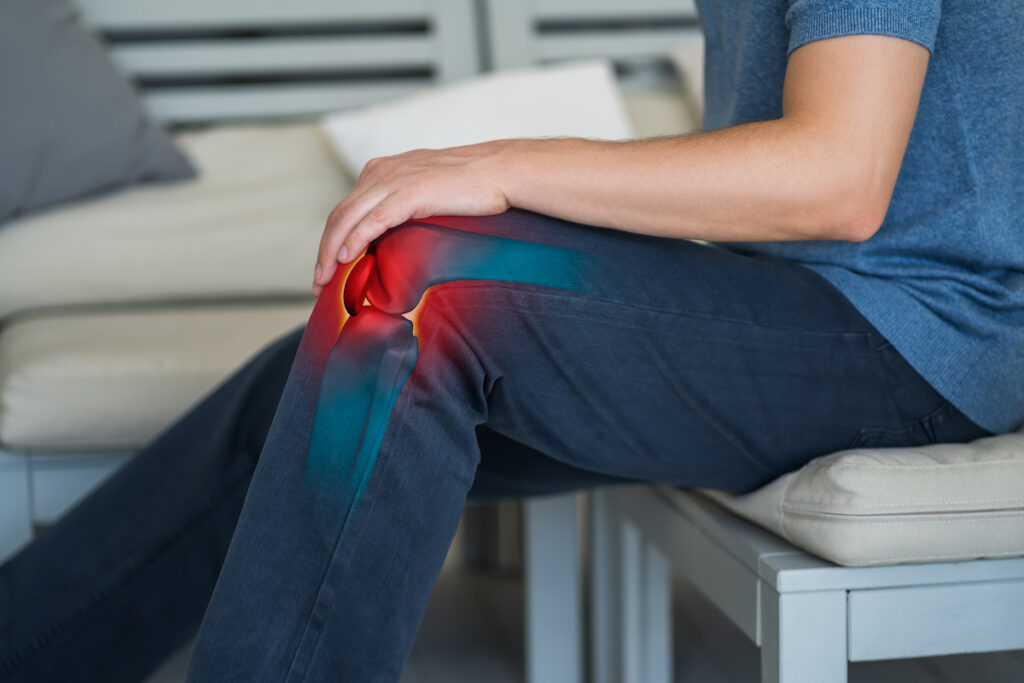 man sitting in a chair suffer from knee bursitis pain