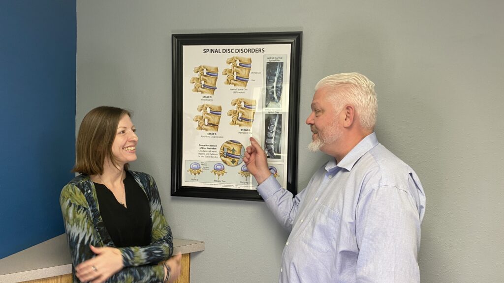 Dr. Westley Kuns with female patient discussed about spine models