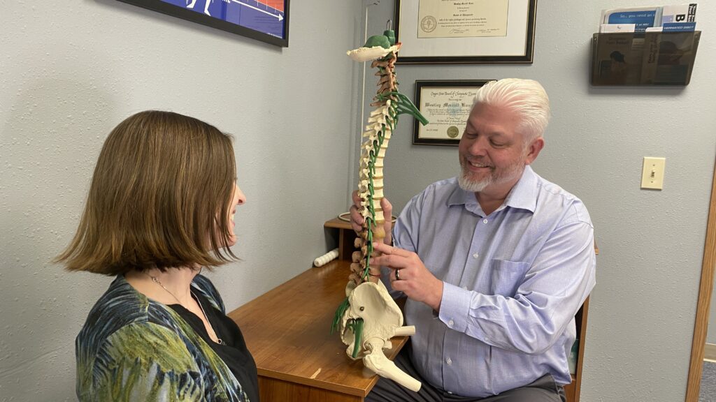 Dr Kuns showing patient a full spina model